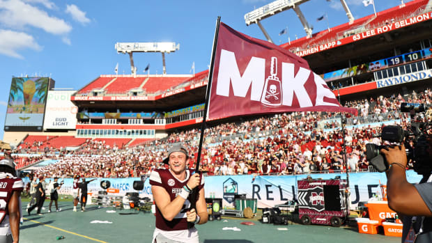 Mississippi State Bulldogs quarterback Will Rogers (2) carries a flag after they beat Illinois Fighting Illini in honor of there head coach Mike Leach in the 2023 ReliaQuest Bowl at Raymond James Stadium.